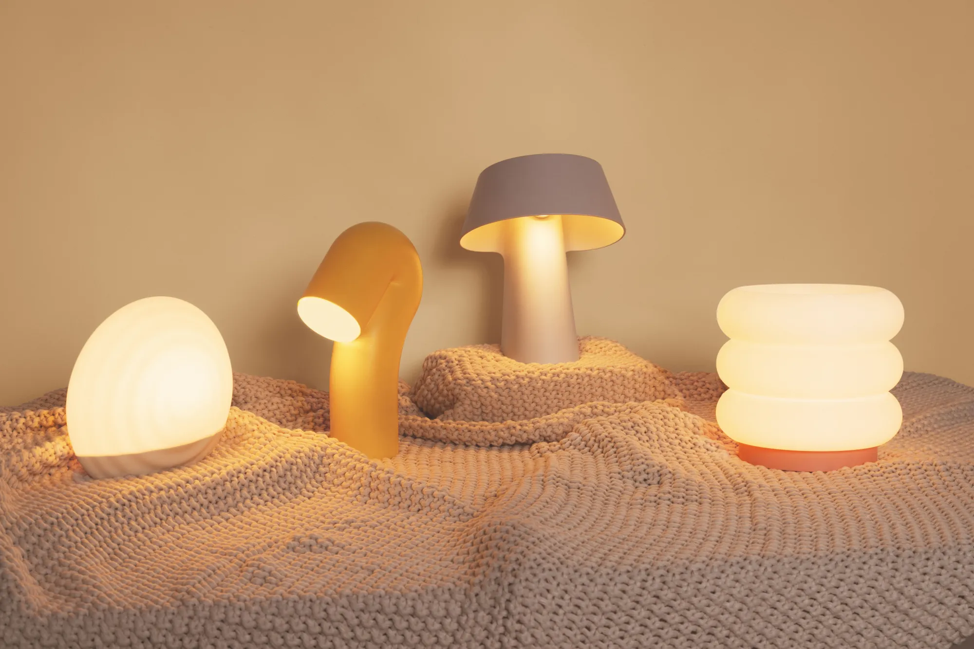 Four table lights by Gantri placed side by side, from left to right: the Kobble Table Light, Smoothy Table Light, Fold Table Light, and Argizari Table Light.