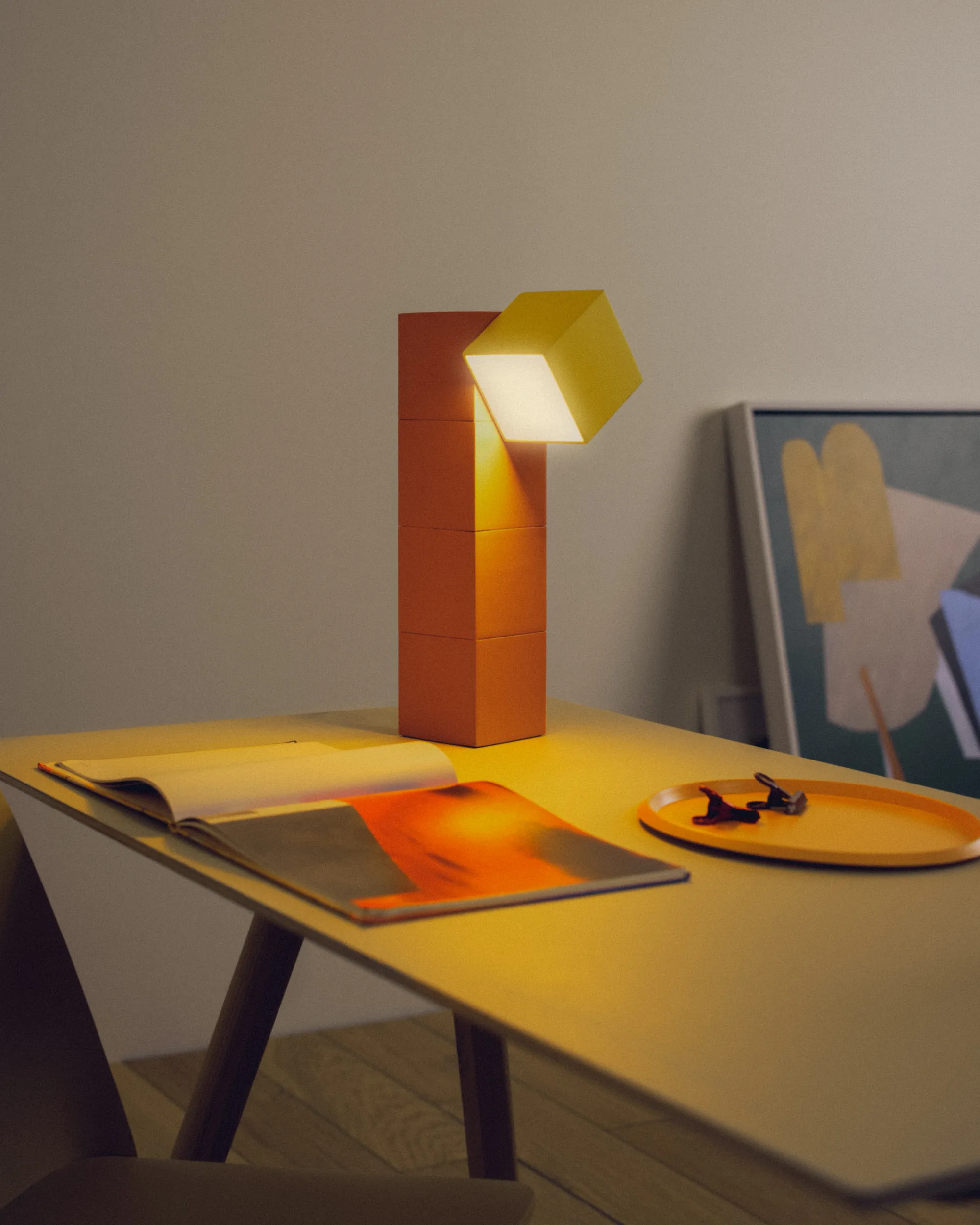 Gantri’s Analog Task Light Table lamp lights up a home office table where a magazine is laid open flat
