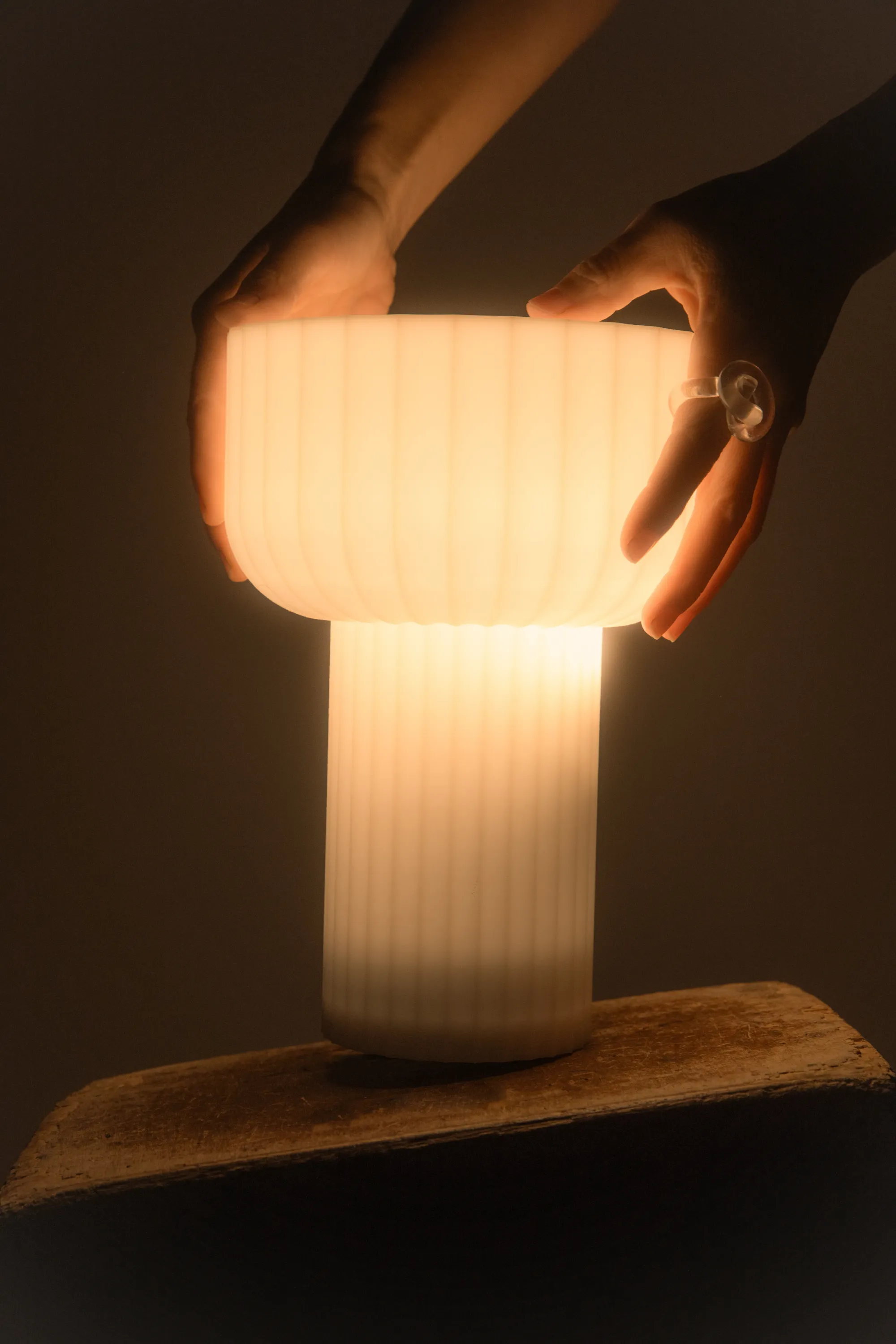 A hand holding a Gantri Word Table Light