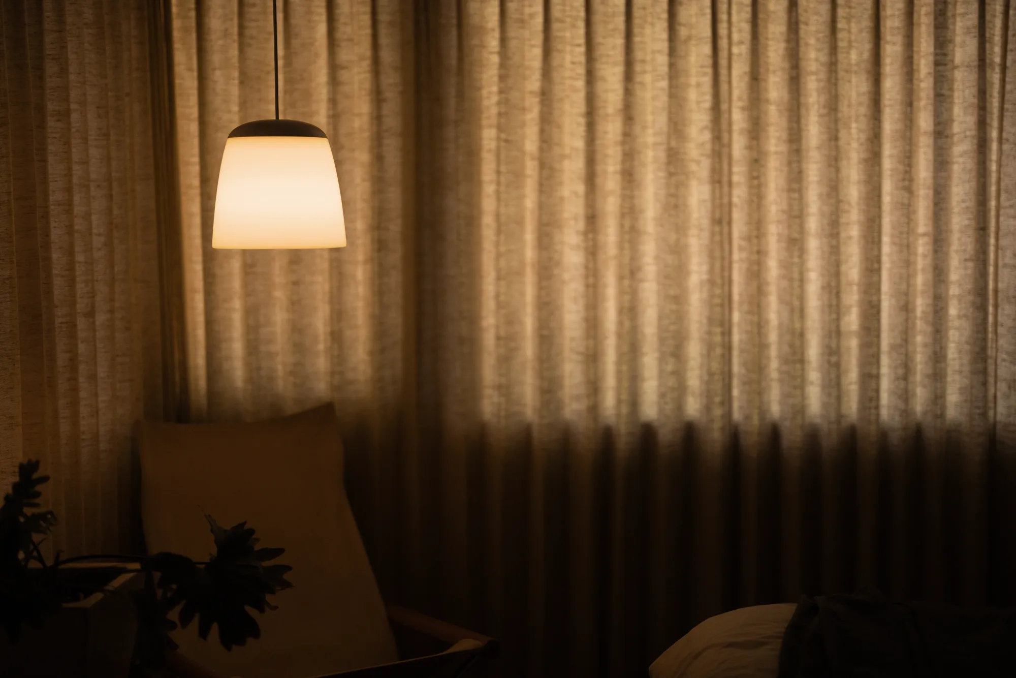 A Gantri Soave Pendant Light hanging over a living room chair