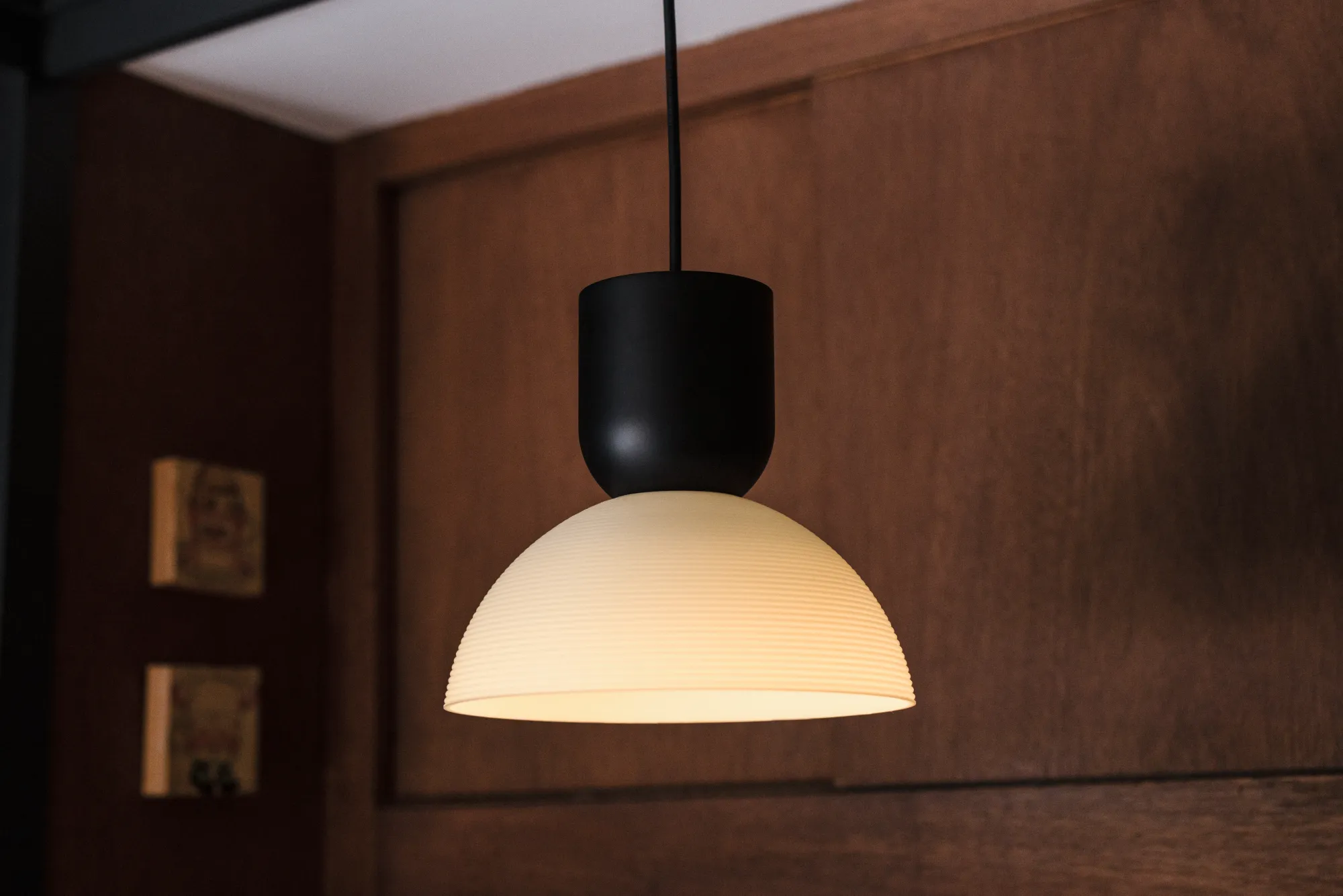 A Gantri Buia Pendant Light lit up and in focus